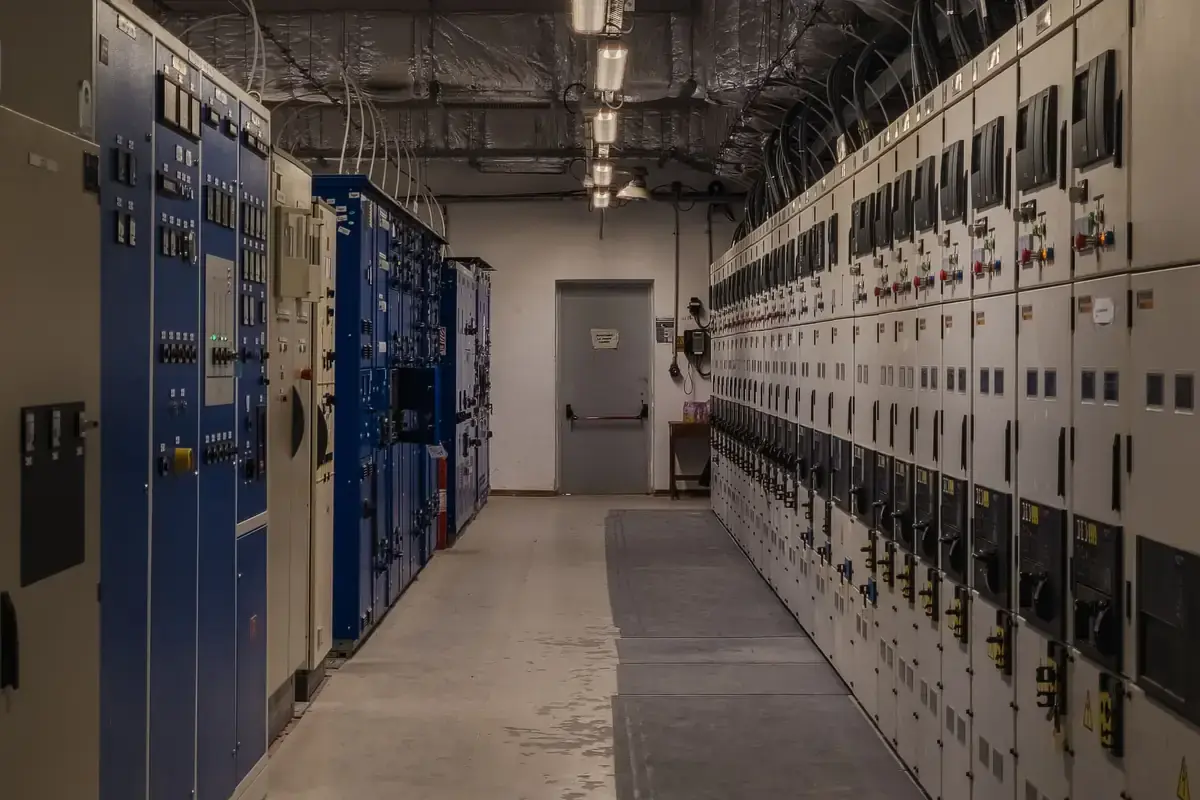 Konzeptvisualisierung: Moderner Schaltanlagenraum mit beleuchteten Steuerungspanelen